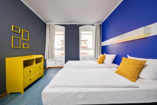 sypialnia z 2 łóżkami i żółtą komodą w obiekcie Old Town Hostel w Berlinie