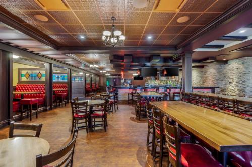 a restaurant with tables and chairs and a bar at Best Western Plus Edmonton Airport Hotel in Leduc