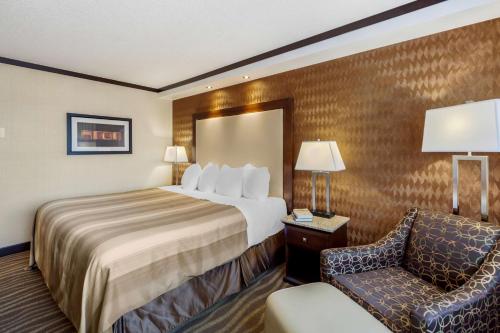 a hotel room with a bed and a chair at Best Western Plus Edmonton Airport Hotel in Leduc