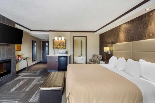 Best Western Plus Edmonton Airport Hotel في ليدوك: غرفة فندقية بسرير كبير ومطبخ