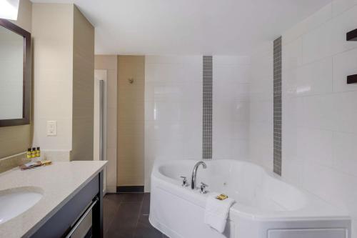 uma casa de banho branca com uma banheira e um lavatório em Best Western Plus Edmonton Airport Hotel em Leduc