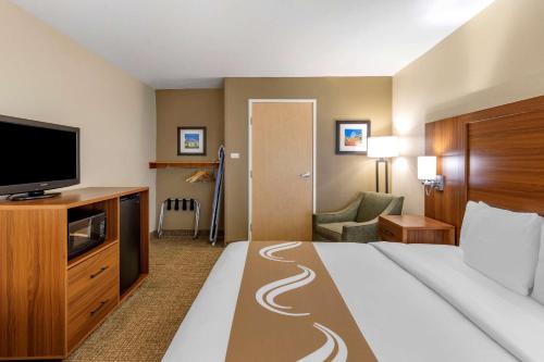a hotel room with a bed and a flat screen tv at Quality Inn Placentia Anaheim Fullerton in Placentia