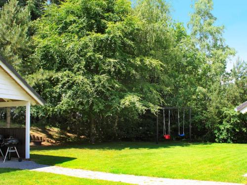 un patio con un árbol con un columpio en 6 person holiday home in Ansager, en Ansager