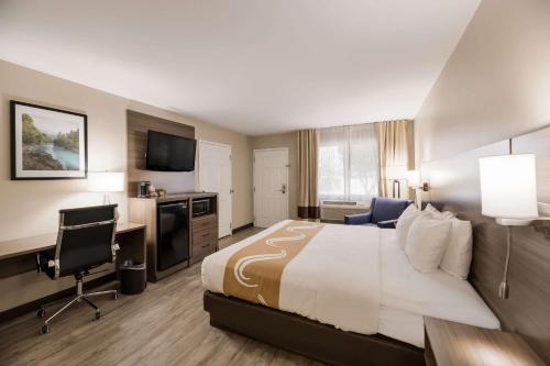 Habitación de hotel con cama grande y escritorio. en Quality Inn en Sonora