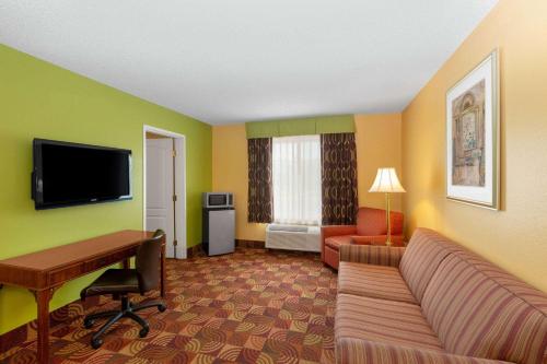 a living room with a couch and a desk at Super 8 by Wyndham Lake of the Ozarks in Eldon