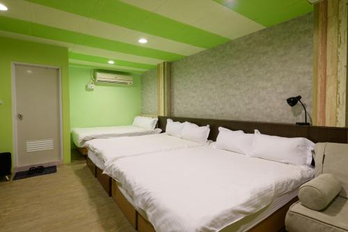 a row of beds in a room with green walls at 羅東小宅一生 in Luodong