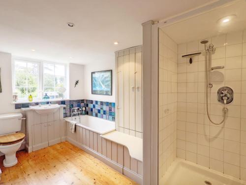 a bathroom with a shower and a tub and a toilet at Dolphin Cottage - Hayling Island in South Hayling