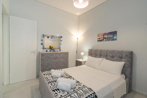 a bedroom with a large bed and a mirror at Comfy Apt next to metro in Athens