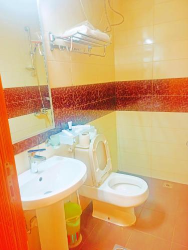 a bathroom with a toilet and a sink at Taraf Yanbu 2 in Yanbu