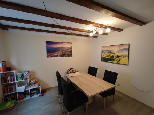 a dining room with a wooden table and chairs at Ferienwohnung Nagelfluh Allgäu in Oberreute
