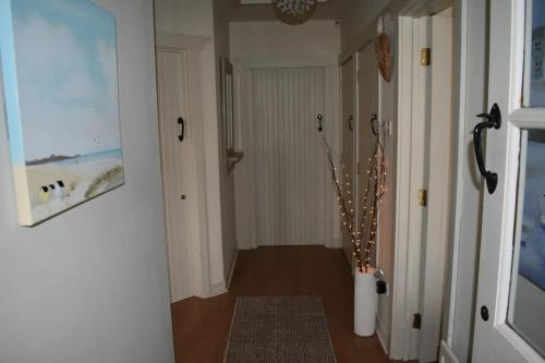 a hallway with a vase of flowers in a room at Holiday Home- Portballintrae in Portballintrae