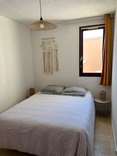 une chambre avec un lit et une fenêtre dans l'établissement Appartement T2 Gruissan port, rive gauche, à Gruissan