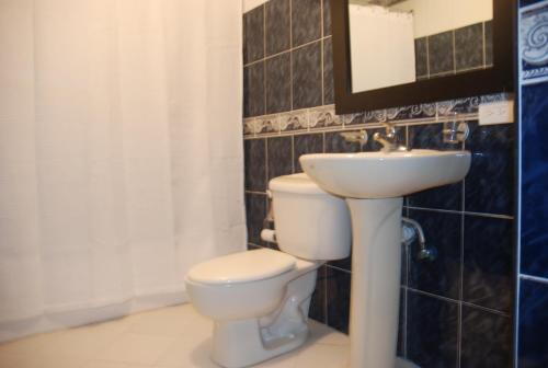 a bathroom with a toilet and a sink at E&J Boutique Residences in Sosúa