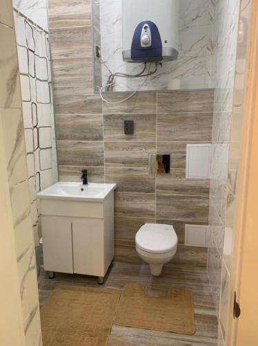 een kleine badkamer met een toilet en een wastafel bij студия Вефа in Bisjkek