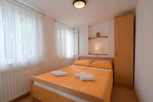 a bedroom with a bed with two towels on it at Apartments Julia in Čižići