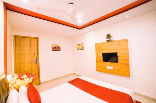 a bedroom with a bed and a tv on the wall at Hotel Grandeur-Near Mumbai International Airport in Mumbai