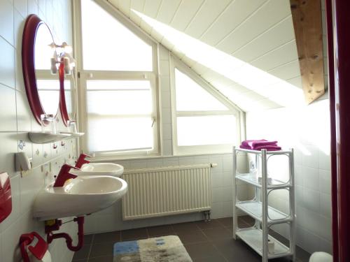 a bathroom with two sinks and two windows at Göttliche Vogelstimmen Gäste aus 57 Nationen in Bad Boll