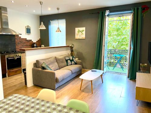 a living room with a couch and a table at Appartement au cœur de breil sur roya in Breil-sur-Roya