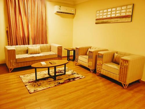 sala de estar con sofás, mesa y sillas en Taraf Yanbu 2, en Yanbu