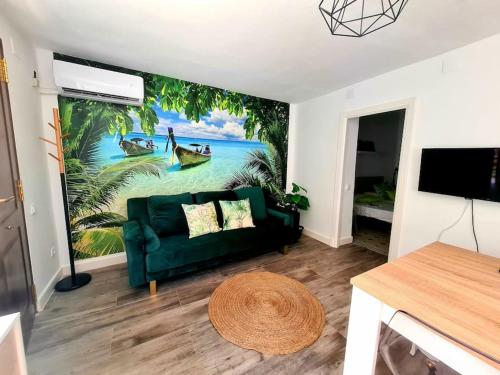 salon z zieloną kanapą i malowidłem ściennym w obiekcie P Casa con Azotea privada y Céntrica. WiFi+Netflix w mieście El Puerto de Santa María
