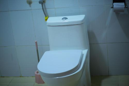 a white toilet in a bathroom with a light on it at Kigezi Gardens Inn in Kabale