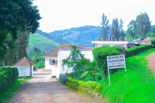 a sign in front of a white house with a street complaints sign at Kigezi Gardens Inn in Kabale