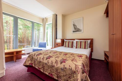 a bedroom with a bed and a large window at Meduza Hotel in Palanga