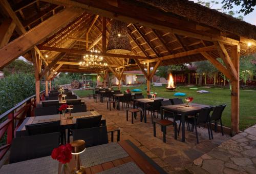 a restaurant with tables and chairs under a pavilion at Dachas Cove Hotel in Agva