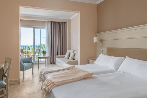 Habitación de hotel con cama y balcón en Iberostar Málaga Playa, en Torrox Costa