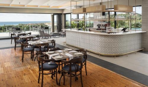 een restaurant met tafels en stoelen en een bar bij Premier Resort Cutty Sark in Scottburgh