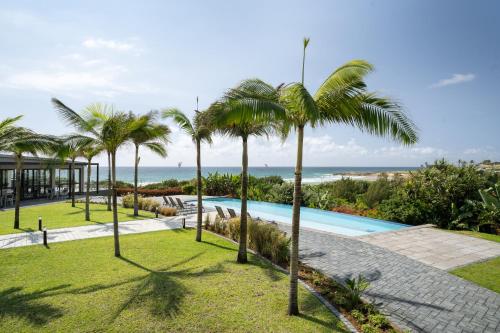 a resort with a swimming pool and palm trees at Premier Resort Cutty Sark in Scottburgh