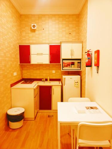 a small kitchen with white appliances and a table at Taraf Yanbu 2 in Yanbu