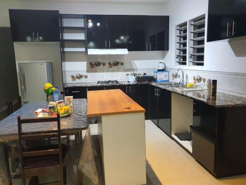 a kitchen with black cabinets and a wooden counter top at Single Room with Shared Kitchen and Living Room in Suva