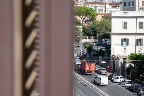 a view of a city street with cars and a truck at DREAMS IN ROME - COLOSSEUM APARTMENT in Rome