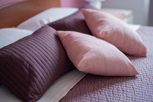a group of pink pillows on a bed at DREAMS IN ROME - COLOSSEUM APARTMENT in Rome