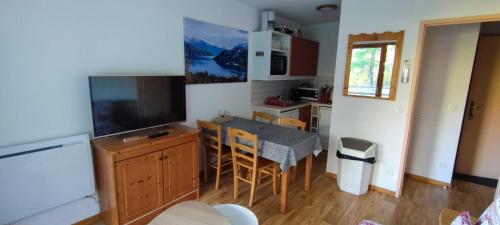 uma cozinha com uma mesa e uma sala de jantar em Charmant appartement de 6 pers tout confort em Puy-Saint-Vincent