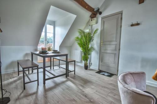 une salle à manger avec une table, des chaises et une plante dans l'établissement Superbe appartement centre-ville, à Nogent-le-Roi
