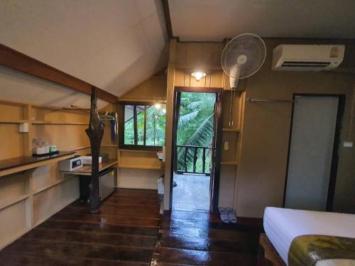 a small room with a bed and a room with a window at Malulee KhaoSok Resort in Khao Sok