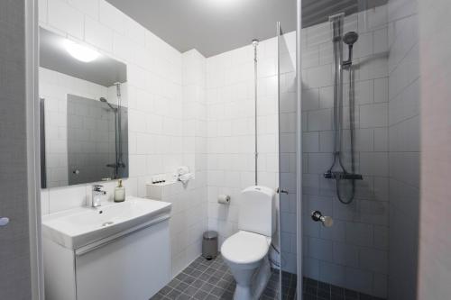 y baño con aseo, lavabo y ducha. en Foundry Hotel Apartments, en Uppsala
