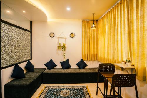 sala de estar con sofá, mesa y sillas en Good vibes en Kallar Vattiyar