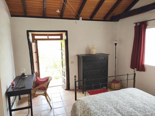 a bedroom with a bed and a desk and a window at Casa Panama in Hermigua