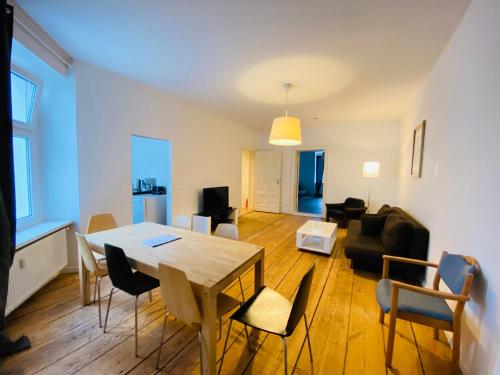ein Wohnzimmer mit einem Holztisch und Stühlen in der Unterkunft BerlinLux Apartments - City in Berlin