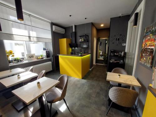 a restaurant with tables and chairs and a yellow counter at A8 b&b in Zagreb