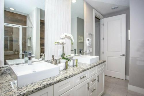 a bathroom with two sinks and a large mirror at 2620 Magical Memories 15 min-Disney in Orlando