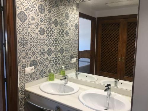 Baño con 2 lavabos y espejo en Moderno apartamento en Bahia Sur, en San Fernando