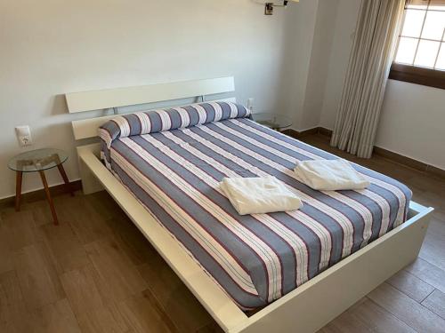 um quarto com uma cama com duas almofadas em Moderno apartamento en Bahia Sur em San Fernando