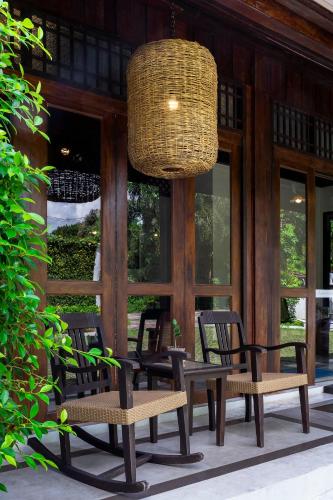 a group of chairs and a table and a chandelier at Ratchapruek Lanna Boutique in Chiang Mai
