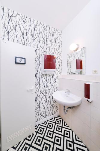 a bathroom with a white sink and black and white wallpaper at Old Town Hostel in Berlin