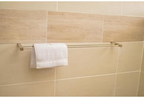 a towel hanging on a towel rack in a bathroom at R Executive Apartments in Harare