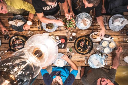 a group of people sitting around a table eating food at Sport & Wellness Hotel Das Falkenstein - Natural Swimming Lake - Matrix GYM - Summercard inklusive - Authentic experience - Flying wellness with Pool in Kaprun